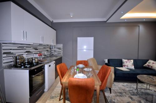 a kitchen and living room with a table and a couch at Arpaçay Apart Otel in Kars