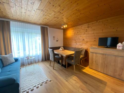 a living room with a table and a blue couch at Appartements Klausner in Altenmarkt im Pongau