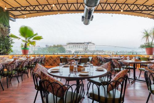 un restaurante con mesas y sillas en un balcón en Hotel Kalinga, en Indore