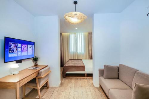 a living room with a couch and a table with a tv at Meriden M Hotel Beijing - Sanlitun Tuanjiehu Subway Station in Beijing