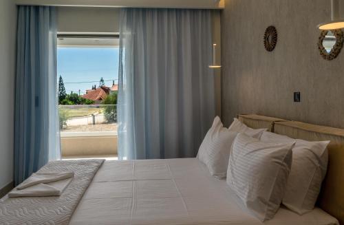 - une chambre avec un grand lit et une fenêtre dans l'établissement Cactus Villas, à Mitikas