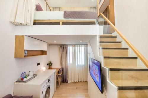 a small apartment with a staircase and a living room at Meriden M Hotel Beijing - Sanlitun Tuanjiehu Subway Station in Beijing