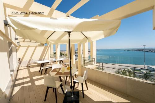 a balcony with a table and chairs and an umbrella at Plaza Mina Suites - Adults Recommended by Luxury Suites Cadiz in Cádiz