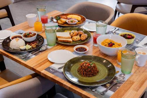a wooden table with plates of food on it at Holiday Inn Sepang - Airport in Sepang