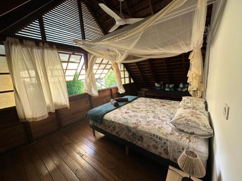 a bedroom with a bed with a mosquito net at Moorea Pool & Lagoon House in Moorea