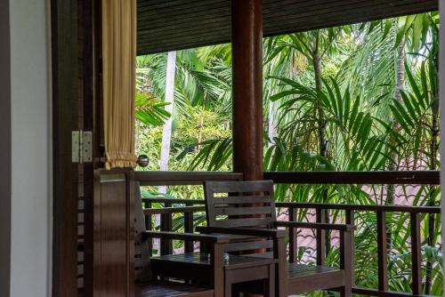 a room with a balcony with a view of palm trees at Baan Chaweng Beach Resort & Spa - SHA Extra Plus in Chaweng