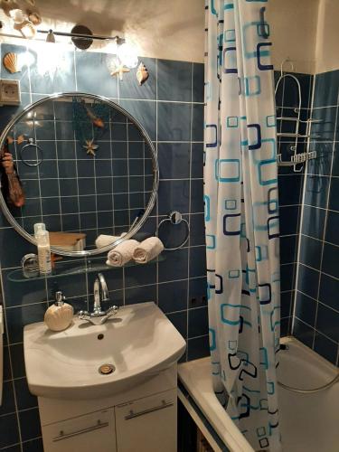 a bathroom with a sink and a shower curtain at Lütte Höög in Sierksdorf