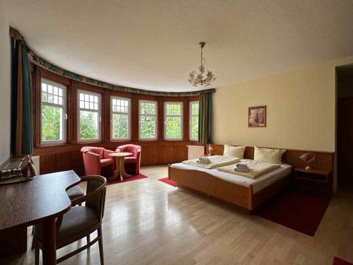 Schlafzimmer mit einem Bett, einem Tisch und Stühlen in der Unterkunft Gaststätte & Pension Waldschlösschen in Oberhof