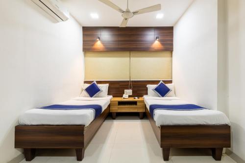 インドールにあるHotel Kalingaの鏡付きの部屋にベッドが2つある