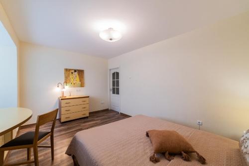 a bedroom with a bed and a desk and a table at A.P. Apartment in Šiauliai