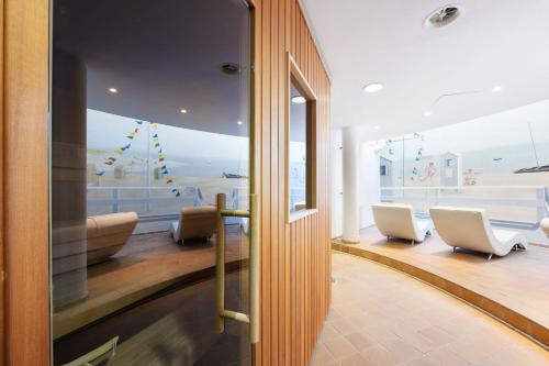 une salle d'attente avec des chaises et une grande fenêtre dans l'établissement Strandhotel Sylt GmbH, à Westerland