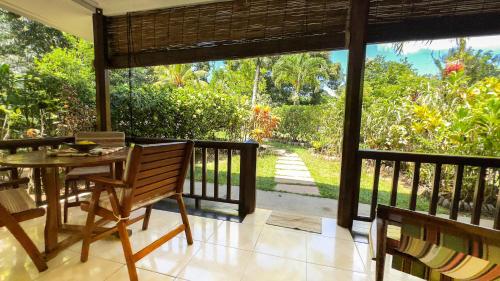 a porch with a table and chairs on a balcony at Cocotier du Rocher in La Digue