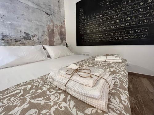 Una cama con dos bolsas blancas encima. en La Nicchia, en Asti