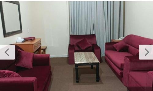 a living room with a couch and a table at Al Jazeerah Hotel in Sharjah