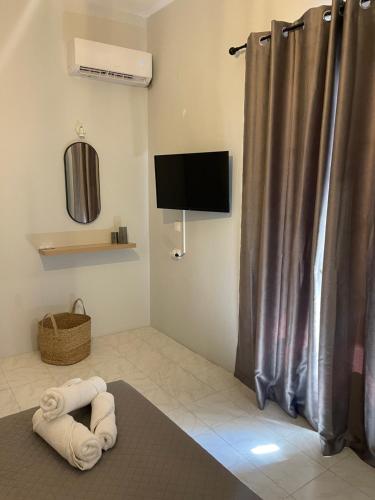 a bathroom with a shower curtain and a television at Sidari Centre Apartments in Sidari