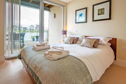 una camera da letto con un grande letto con asciugamani di Howells Mere 26, Swans Down - P a Somerford Keynes