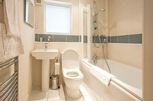a bathroom with a toilet and a sink and a tub at Howells Mere 26, Swans Down - P in Somerford Keynes