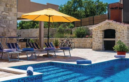 a swimming pool with chairs and an umbrella next to a swimming pool at Villa Petmat - with private pool and 6 bedrooms in Dubrovnik