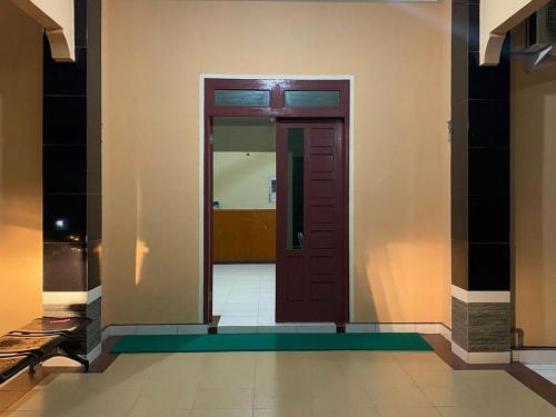 a hallway with a red door in a building at Pondok Indah Syariah near Suzuya Mall Langsa RedPartner in Birimpontong