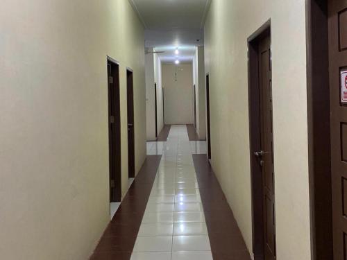 an empty hallway with doors and a tile floor at Pondok Indah Syariah near Suzuya Mall Langsa RedPartner in Birimpontong