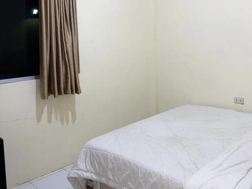 a bedroom with a white bed and a window at Pondok Indah Syariah near Suzuya Mall Langsa RedPartner in Birimpontong