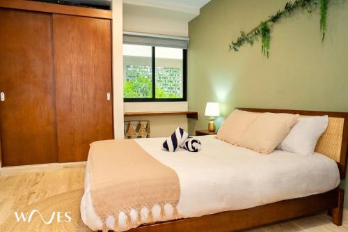 Un dormitorio con una cama y una ventana grande. en 1 Rec. | Vista a la Jungla + Piscina Infinita + Amenidades LX, en Tulum