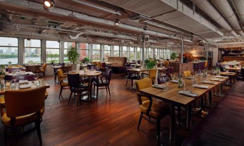 un ristorante con tavoli e sedie in legno e finestre di ss Rotterdam by WestCord a Rotterdam