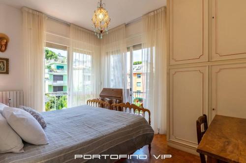 a bedroom with a bed and a table and windows at Appartamento Via Madonnetta by PortofinoVip in Santa Margherita Ligure