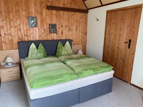 a bedroom with a bed with a green comforter at Ferienwohnungen Rießling in Elend