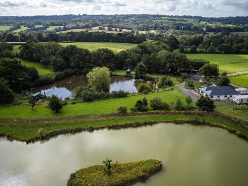 an aerial view of two lakes in a field at Charming tranquil Shepherds Hut with lakeside balcony 'Roach' in Uckfield