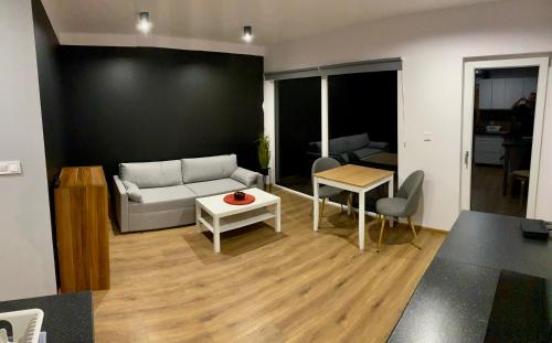 a living room with a couch and a table at Apartamenty Widokowe Na Szczycie in Korbielów