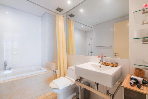 a bathroom with a sink and a toilet and a tub at Park view Avalon Apartment District 1 HCM City in Ho Chi Minh City