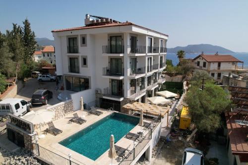 a large white building with a swimming pool in front of it at Kas Athena Hotel in Kas
