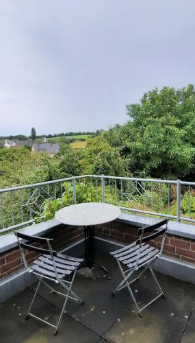 a table and two chairs sitting on a balcony at Panorama-Suite Birkenbeul in Birkenbeul