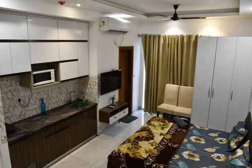 um quarto com uma cozinha e uma sala de estar em The Forest Stays-Luxury Studio Apartment In Noida em Noida