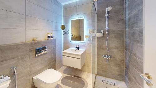 een badkamer met een douche, een toilet en een wastafel bij Al Fares Luxury furnished Apartment-Damac Tower in Amman