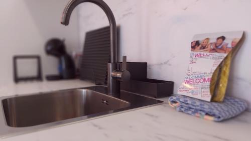 a stainless steel sink in a kitchen with a book at Del Parque Flats Urban Relax in Málaga