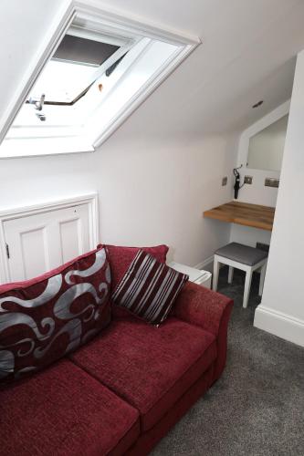 a living room with a red couch and a skylight at Brighton Inn Boutique Guest Accommodation in Brighton & Hove