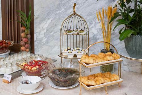 ニャチャンにあるAnnova Nha Trang Hotelのペストリーと鳥かごが並ぶビュッフェ