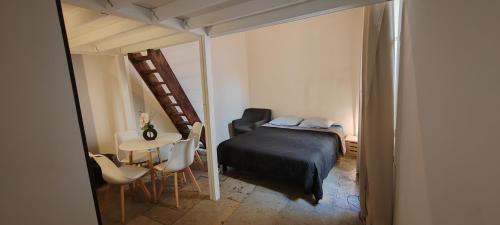 モンペリエにあるパレ デ ロワ ダハグンのベッドルーム1室(ベッド1台、テーブル、椅子付)