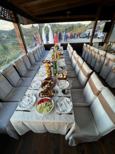 une longue table avec des assiettes de nourriture dans l'établissement Etno selo Kaćo, à Sjenica