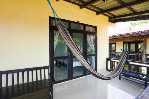 a porch with a hammock hanging from a house at Mr Tho's Bungalows in Don Det