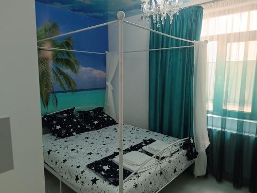 a bedroom with a white canopy bed with a palm tree at Mihail apartament in Năvodari
