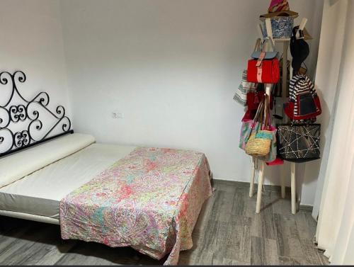 1 dormitorio con 1 cama con bolsos y bolsas en la pared en Apartamento Los Carmenes, playa de Gandia, en Playa de Gandía