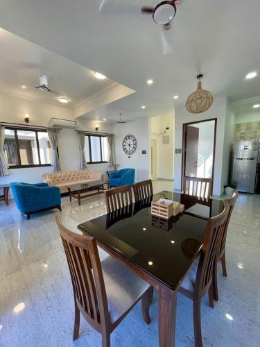 een woonkamer met een tafel en stoelen en een bank bij Redhomex Dolce Vita Villa in Lonavala