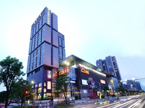um edifício alto numa rua da cidade à noite em Hampton by Hilton Zhuhai Cheng Feng Plaza em Zhuhai