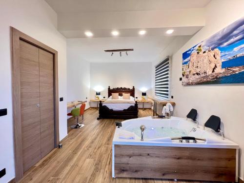 een badkamer met een bad en een slaapkamer met een bed bij Carrubba's luxury home in San Giovanni la Punta
