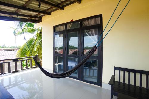a hammock hanging on the side of a house at Mr Tho's Bungalows in Don Det