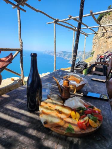stół z talerzem jedzenia i butelką wina w obiekcie Valle degli Dei w mieście Agerola