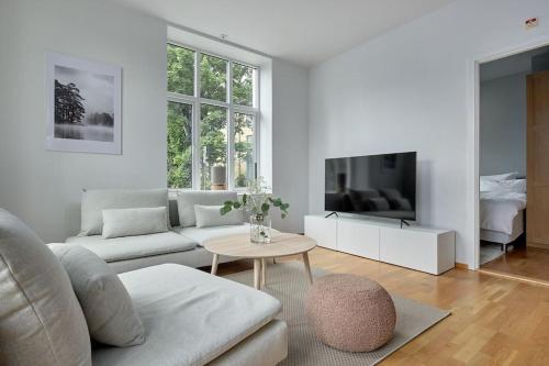 Sala de estar blanca con sofá y mesa en Lys & luksuriøs leilighet midt i Bergen sentrum! en Bergen